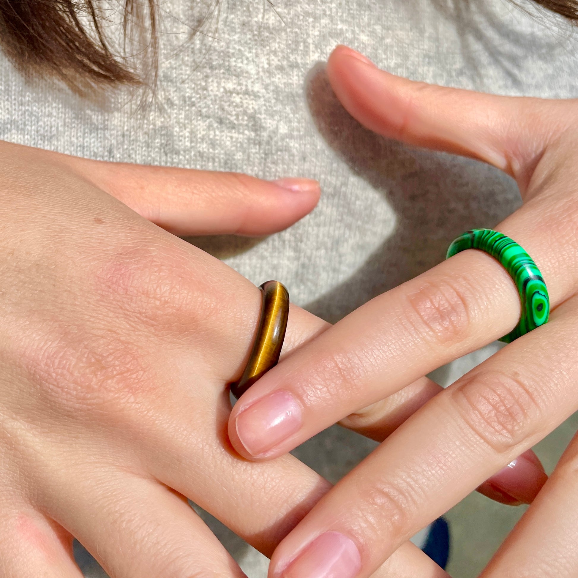 tiger's eye and malachite rings on woman's hands, by whitestone jewelry co.