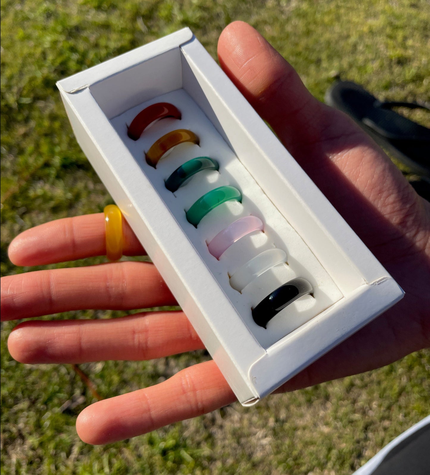 woman holding the whitestone jewelry co. 7 piece shakra stone ring set