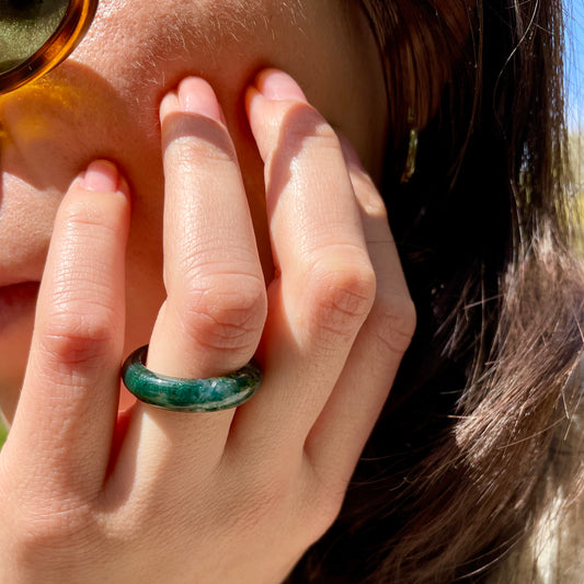 carmela moss agate stone ring from whitestone jewelery co worn by woman resting her hand on face