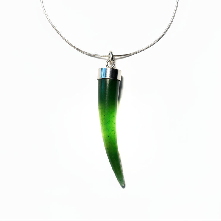one green horn-shaped jade cornicello with silver accents on a white background strung on a silver chain.