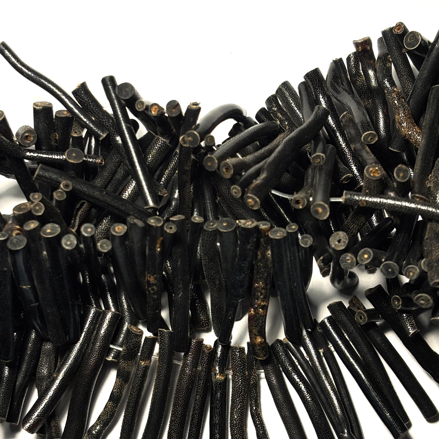 Close-up of a pile of black coral pieces on a white background