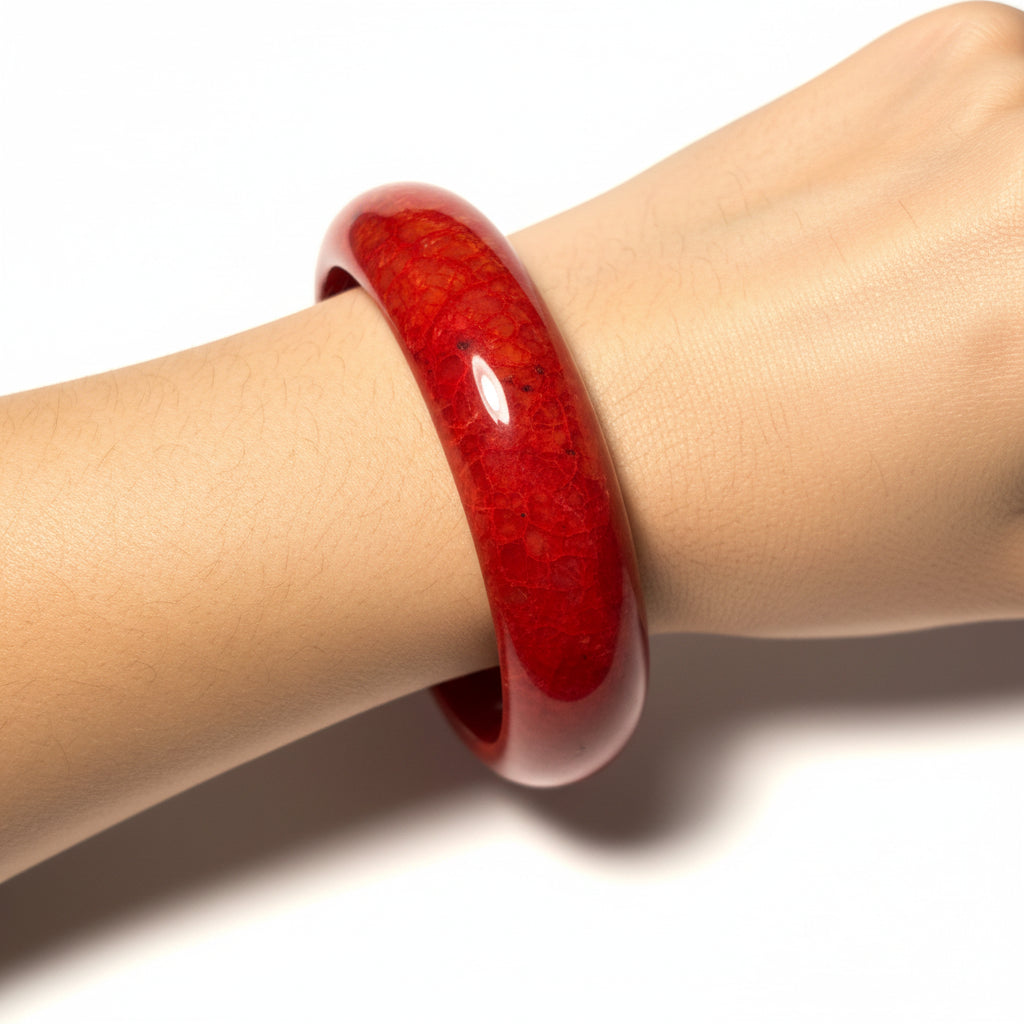 one chicken blood red bangle on a womans are against a white background