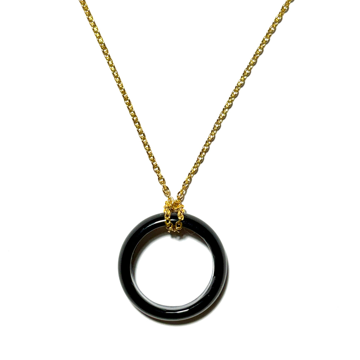 A gold chain necklace with a black circular pendant suspended from a small gold cap, shown against a plain white background.