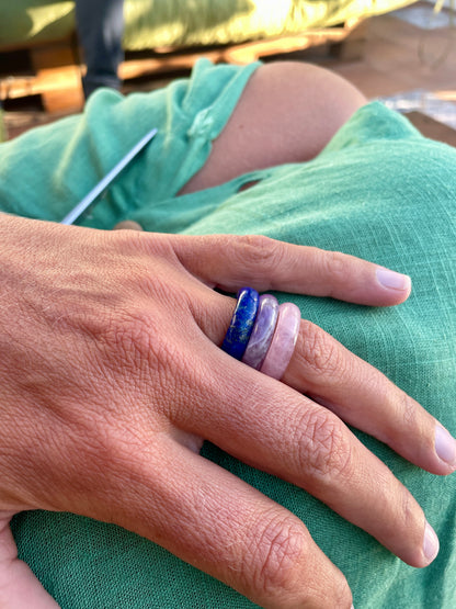 royal lapis lazuli, amethyst, and rose quartz rings paired together on a female model with her hand resting on her green  dress.