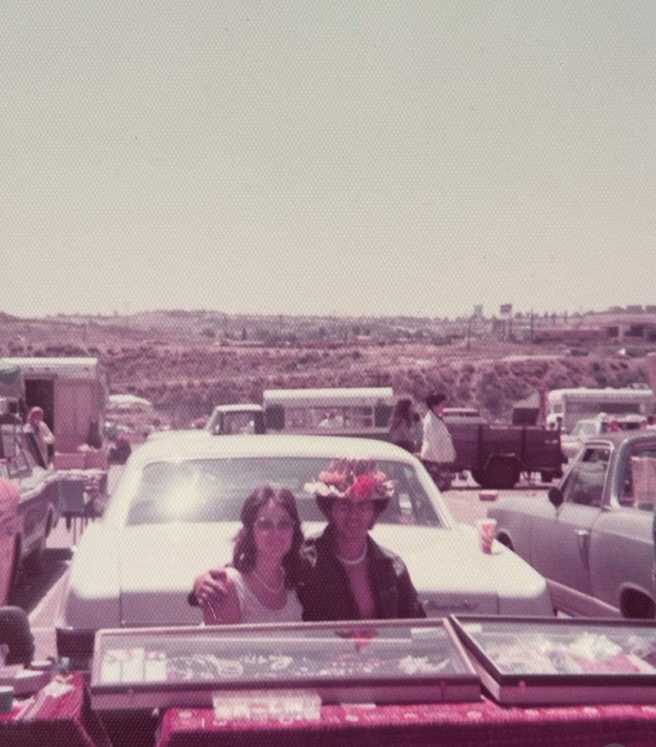 A 1970s image of a man and woman sitting behind a car selling jewelry in san diego 