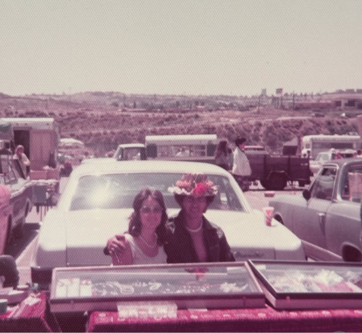Two people in a vintage car with a scenic background
