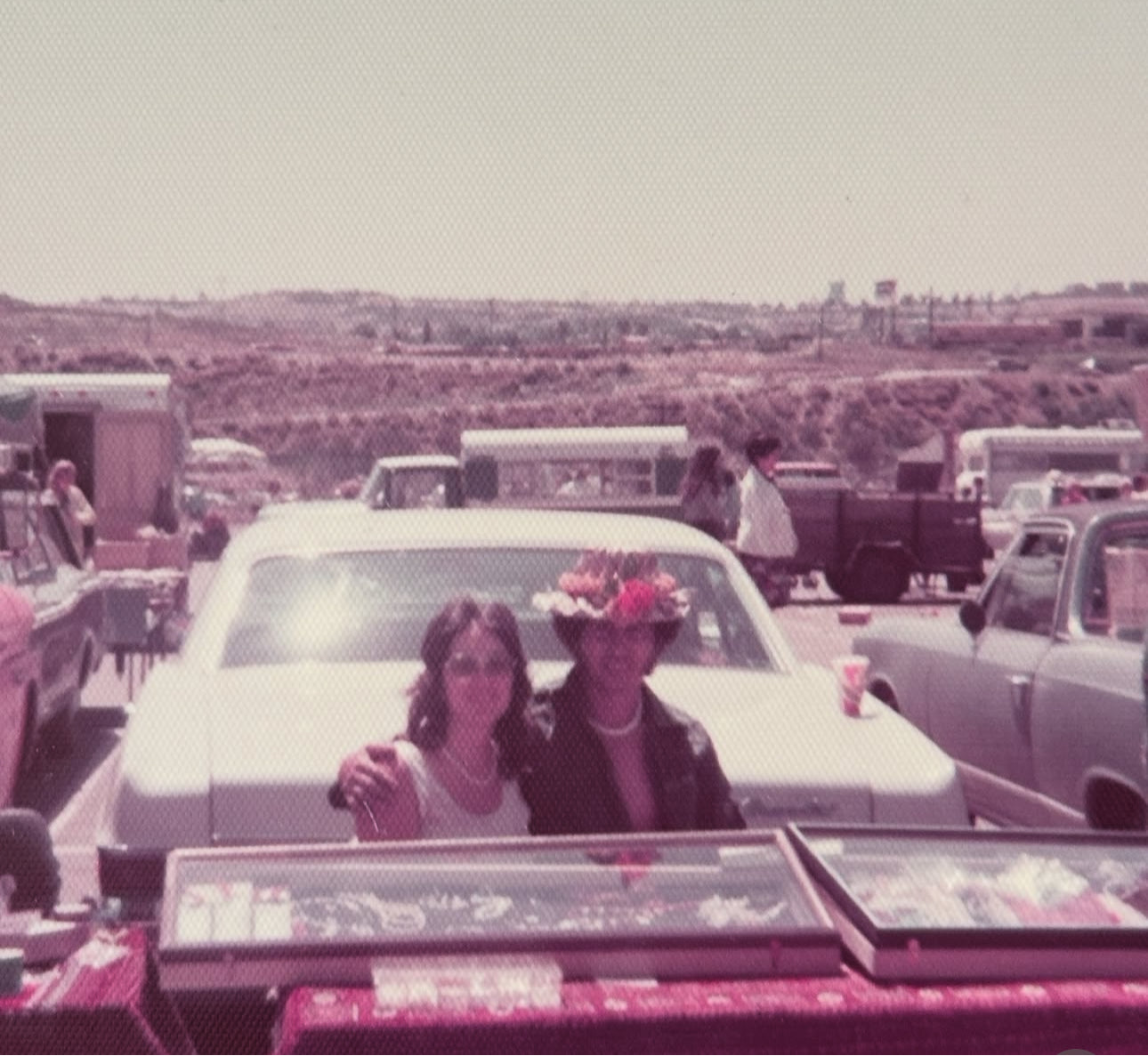 Two people in a vintage car with a scenic background