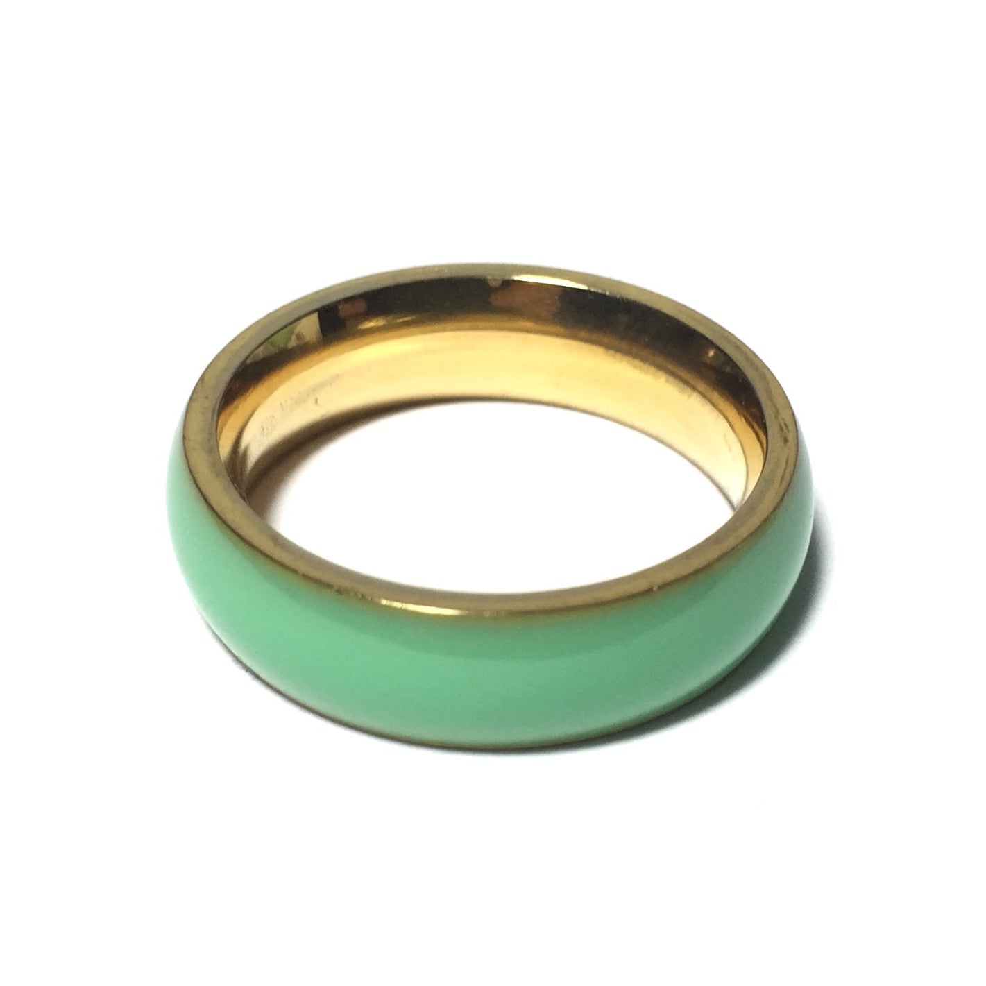 A gold-plated band ring with a seafoam green color.