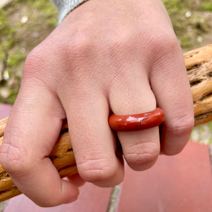 red jasper ring on woman's hand holding a piece of wood, by whitestone jewelry co.