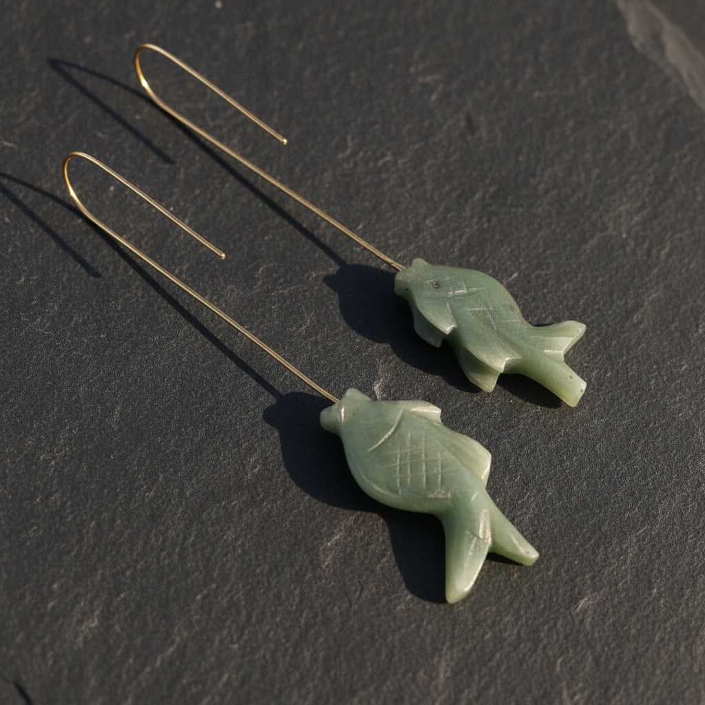 A pair of vintage green jade fish earrings with 18K gold plated drop hooks.