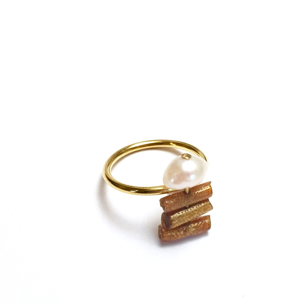 An 18K gold plated ring with a vintage natural gold coral and a cultured pearl on a white background.