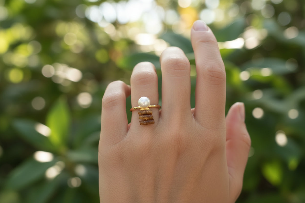 woman wearing a 18K gold plated ring with gold coal and mother of pearl attached to top